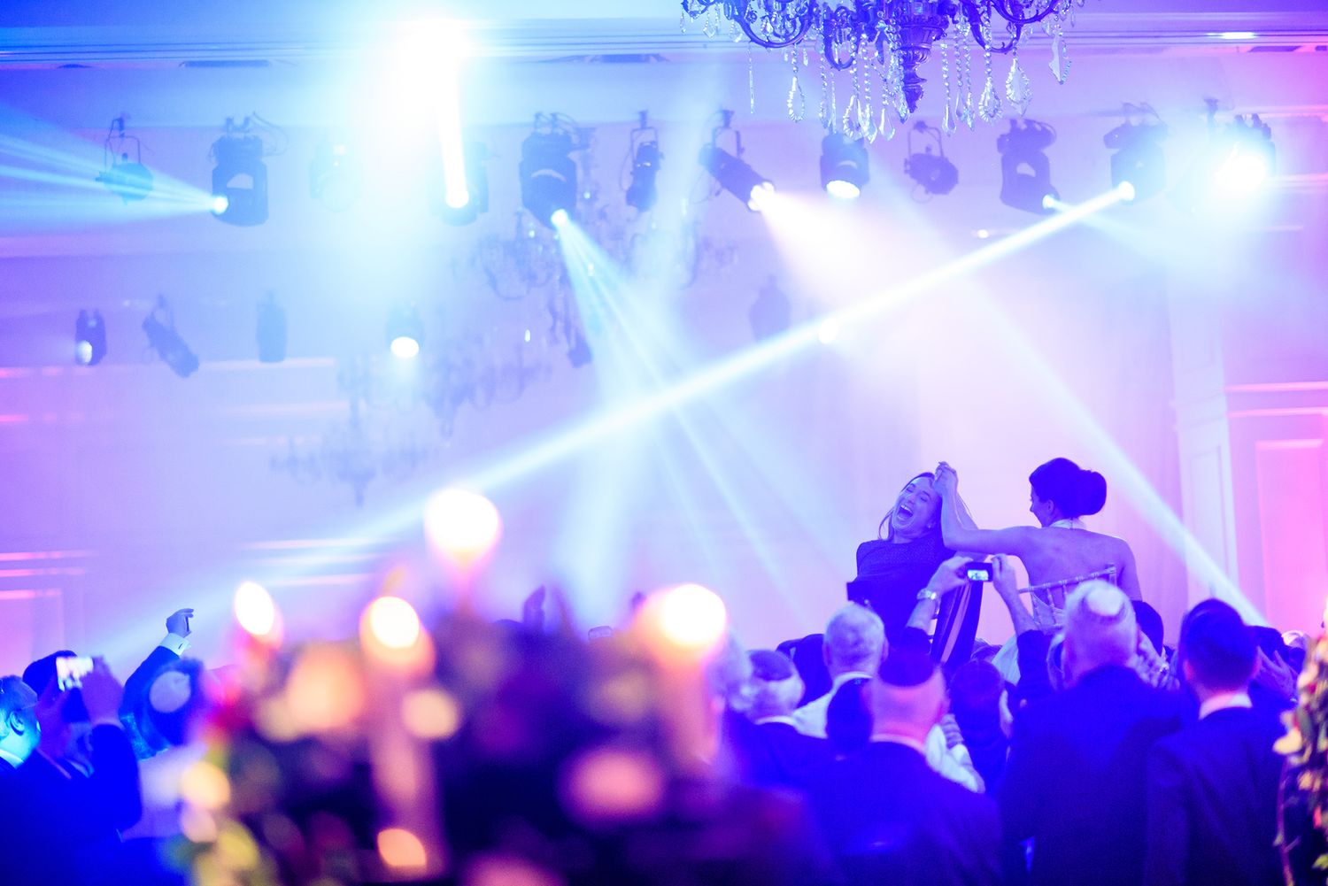 Dynamic concert lighting with blue and purple beams cutting through atmospheric haze.