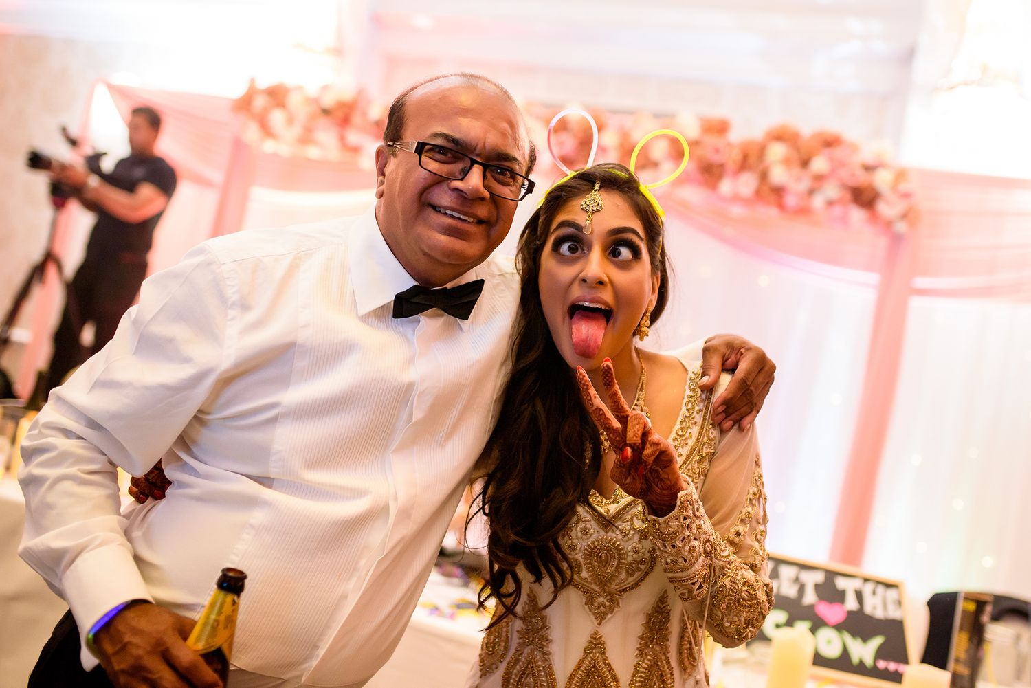 Wedding celebration with guests dancing and enjoying themselves under warm lighting.