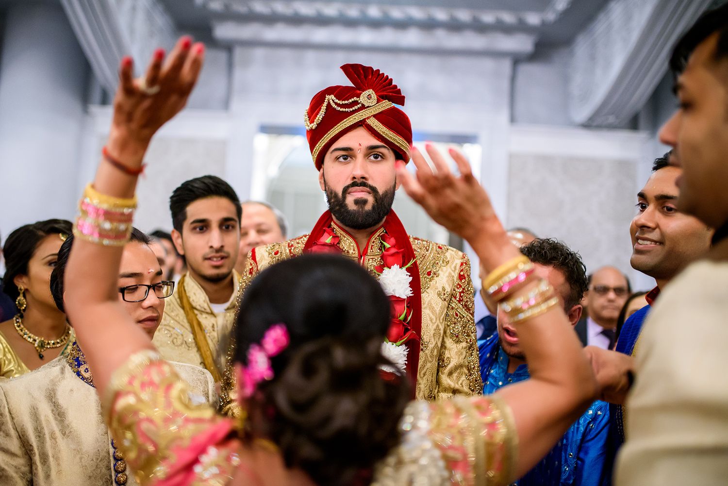 Wedding guests in vibrant traditional Indian outfits celebrating during a ceremony.