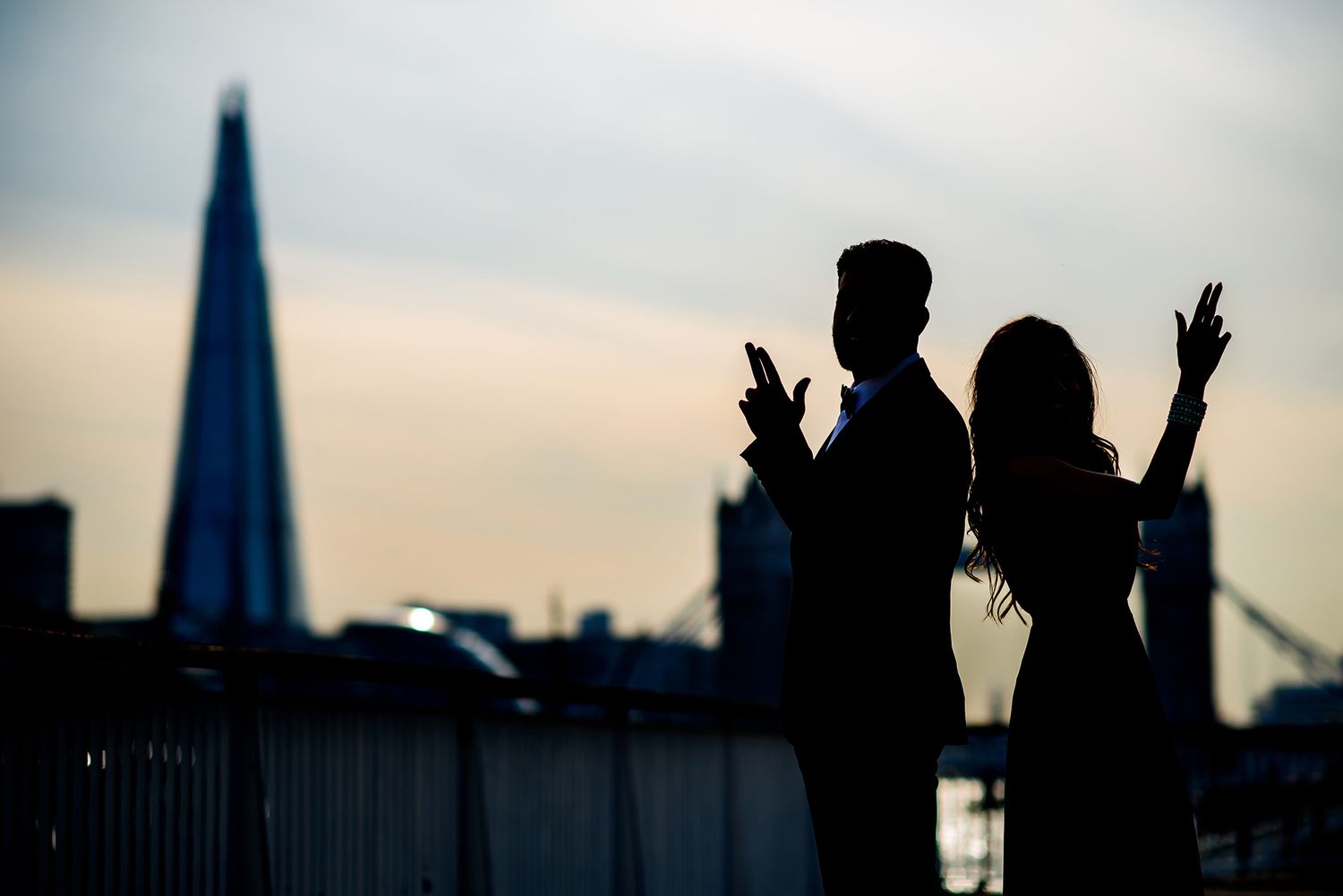 Silhouettes against London skyline with The Shard visible at sunset.