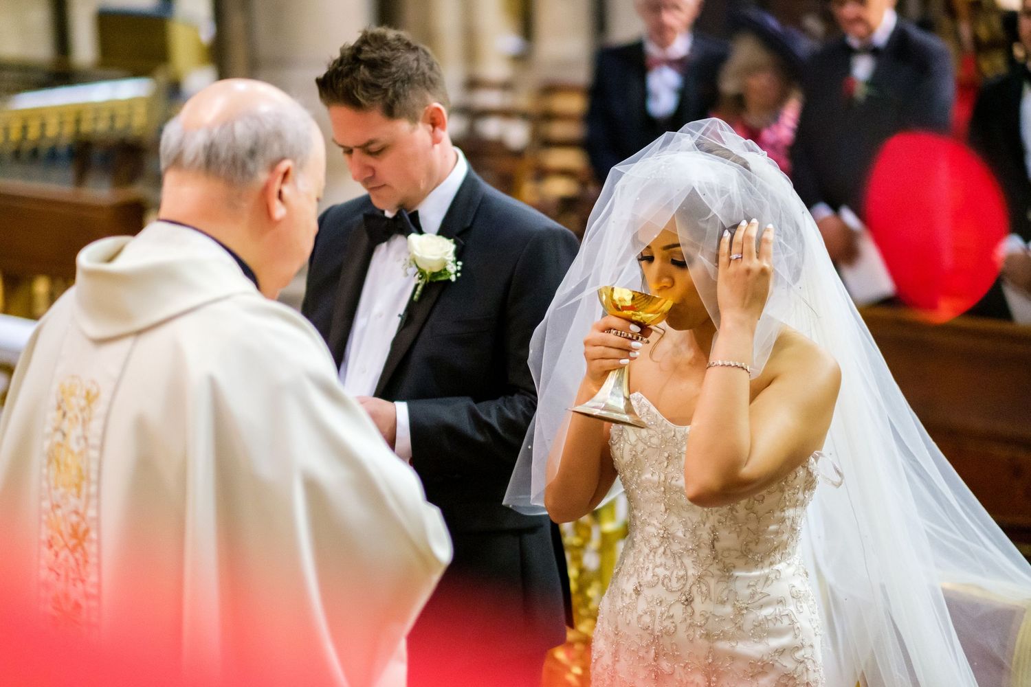 Traditional wedding ceremony taking place in historic cathedral with elegant decor.