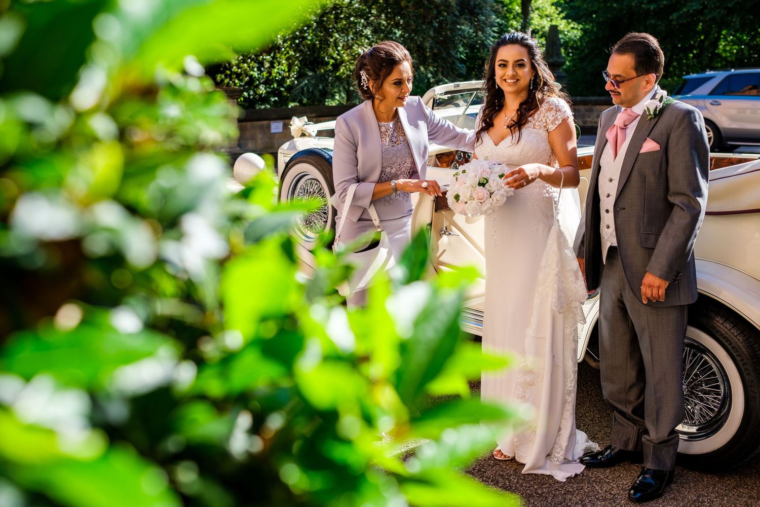 Wedding party members walking and laughing together outdoors on a sunny day.