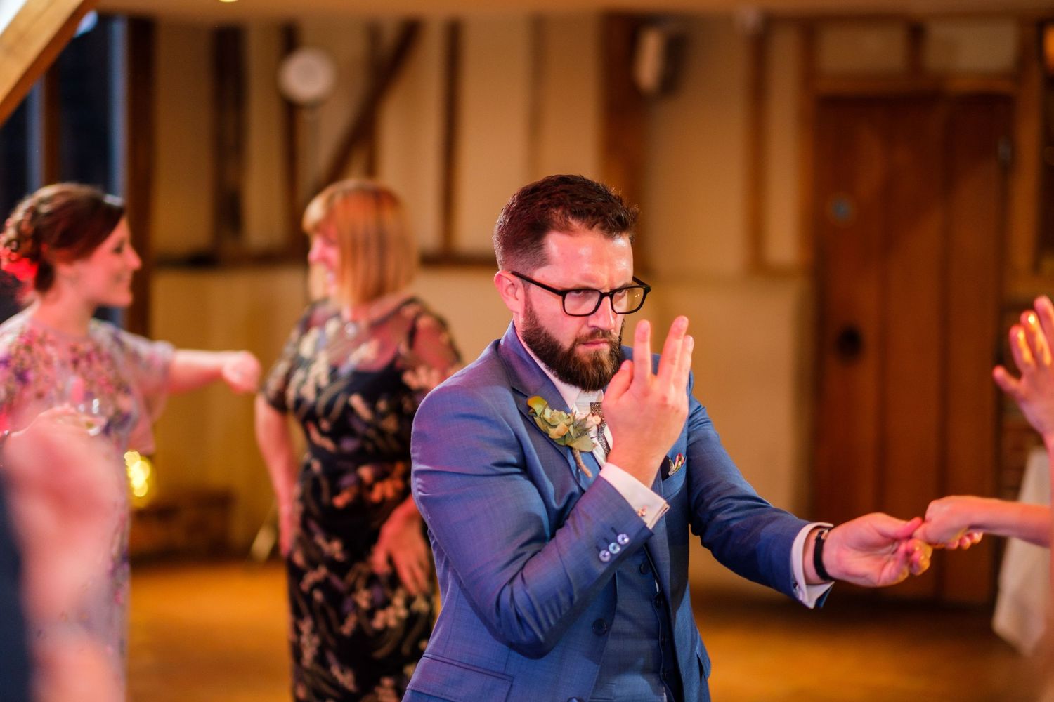 Wedding reception guests sharing emotional moments in an indoor venue.