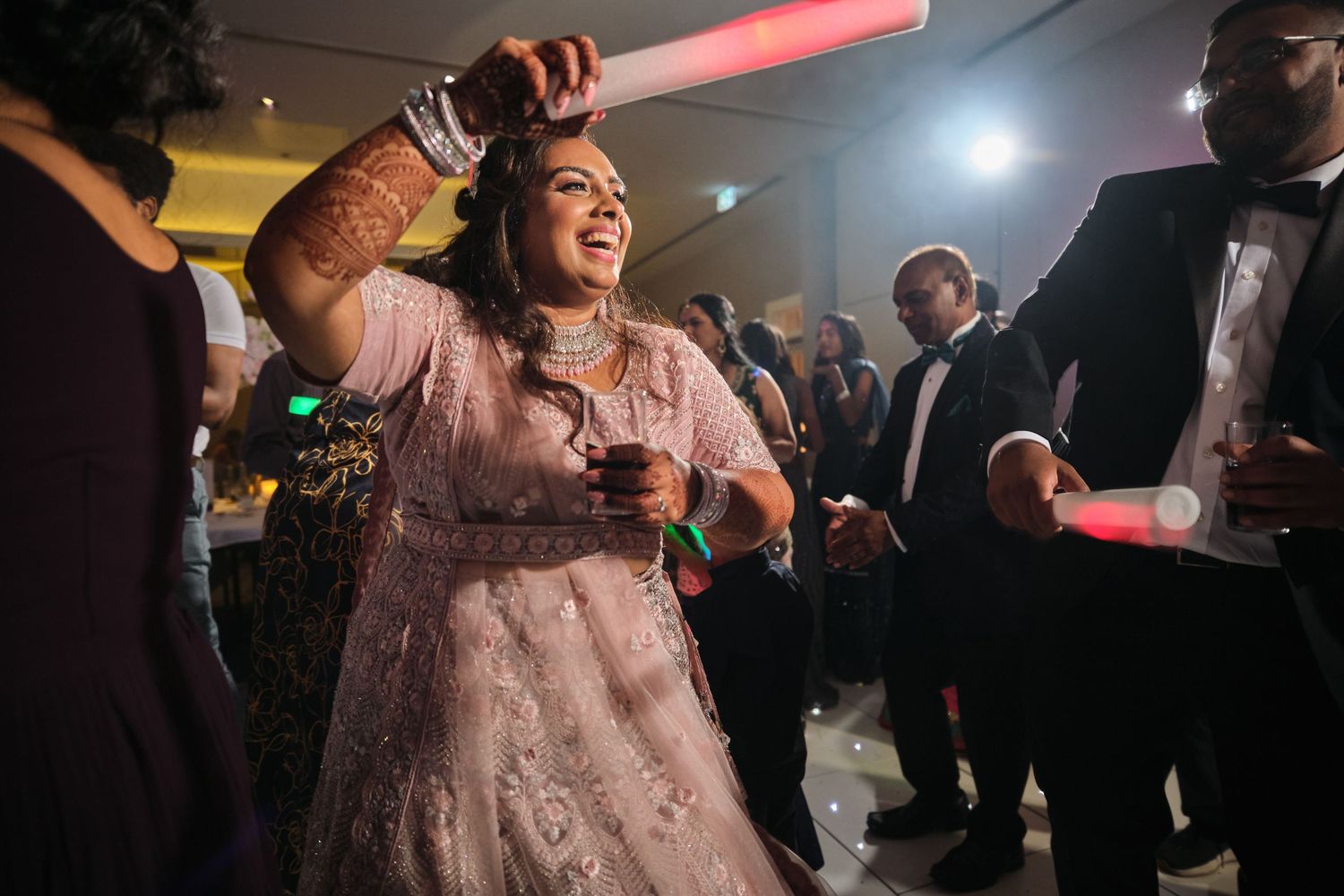 People dancing and celebrating at a lively nightclub party with colorful lighting and festive atmosphere.