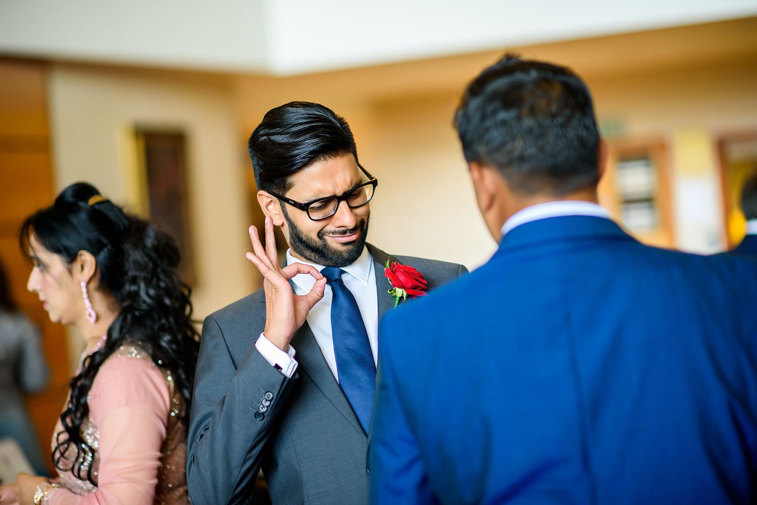 Celebratory scene with guests in formal attire mingling at an indoor wedding reception.
