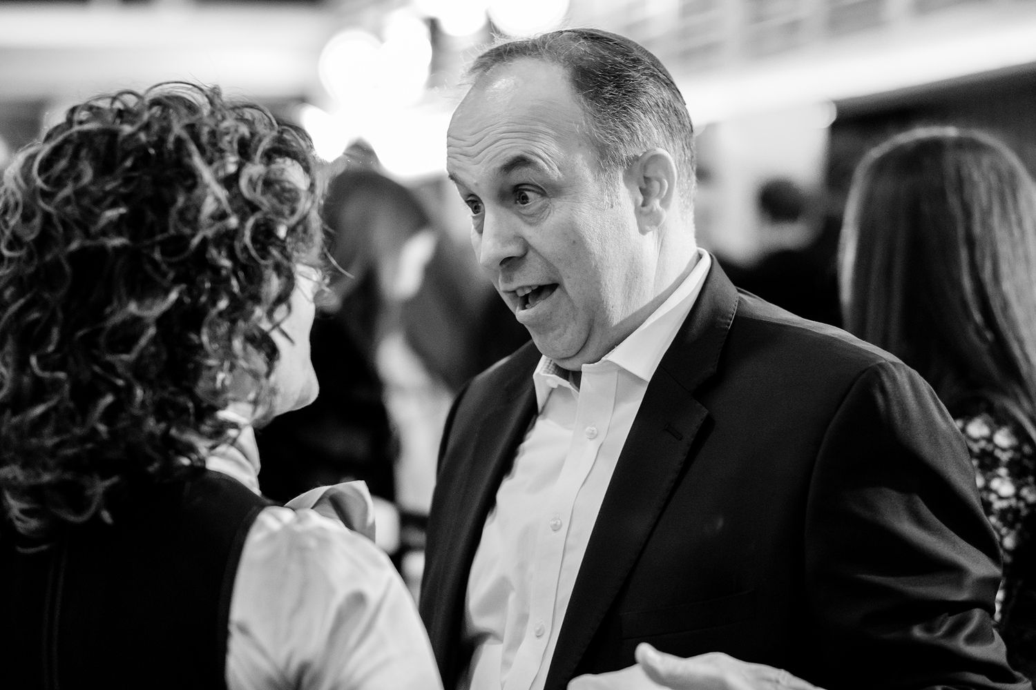 Candid black and white shots of people enjoying a formal celebration.