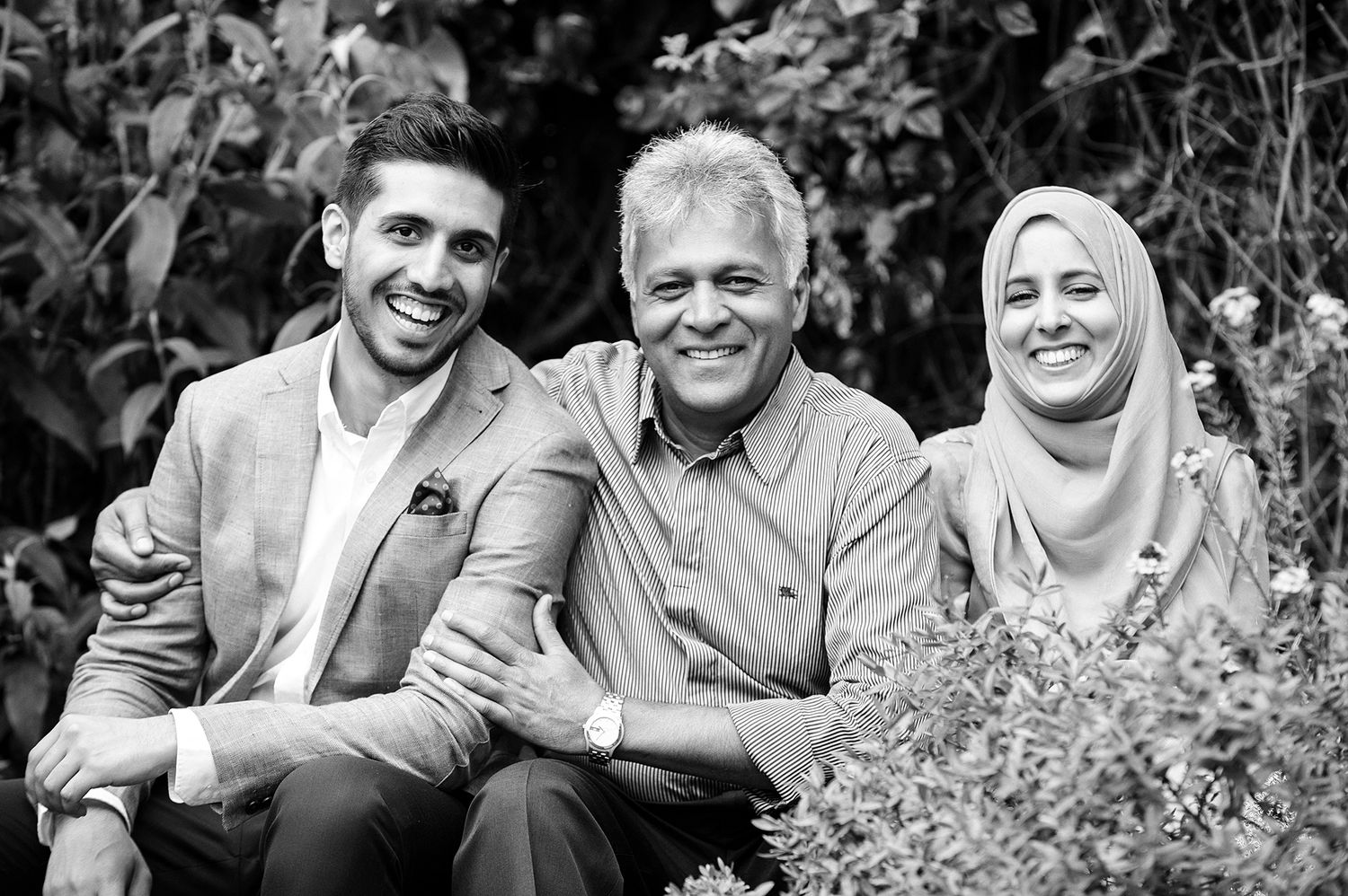 Happy group portrait outdoors with greenery in the background.