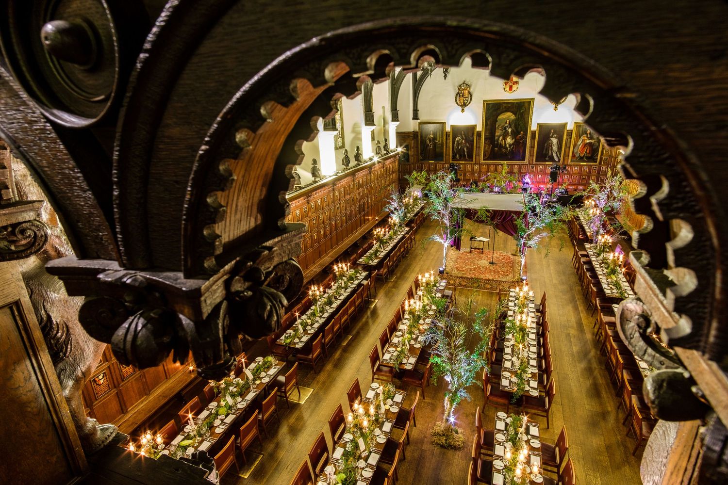 Aerial view of an ornate banquet hall with wooden beams and elegant table settings for a special event.
