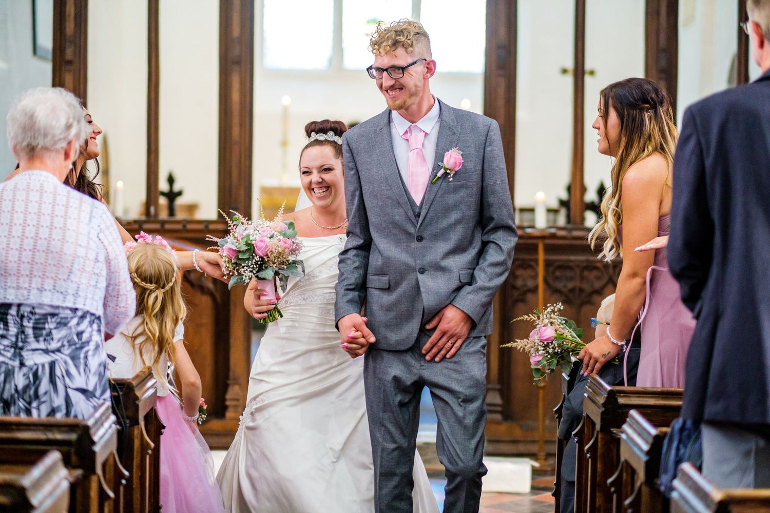 Wedding reception guests mingle and socialize in an indoor venue with wooden beams.