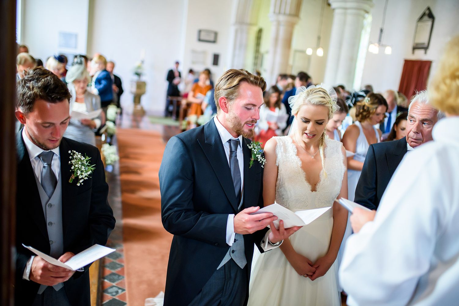 Interior of a church filled with wedding guests during a ceremony.
