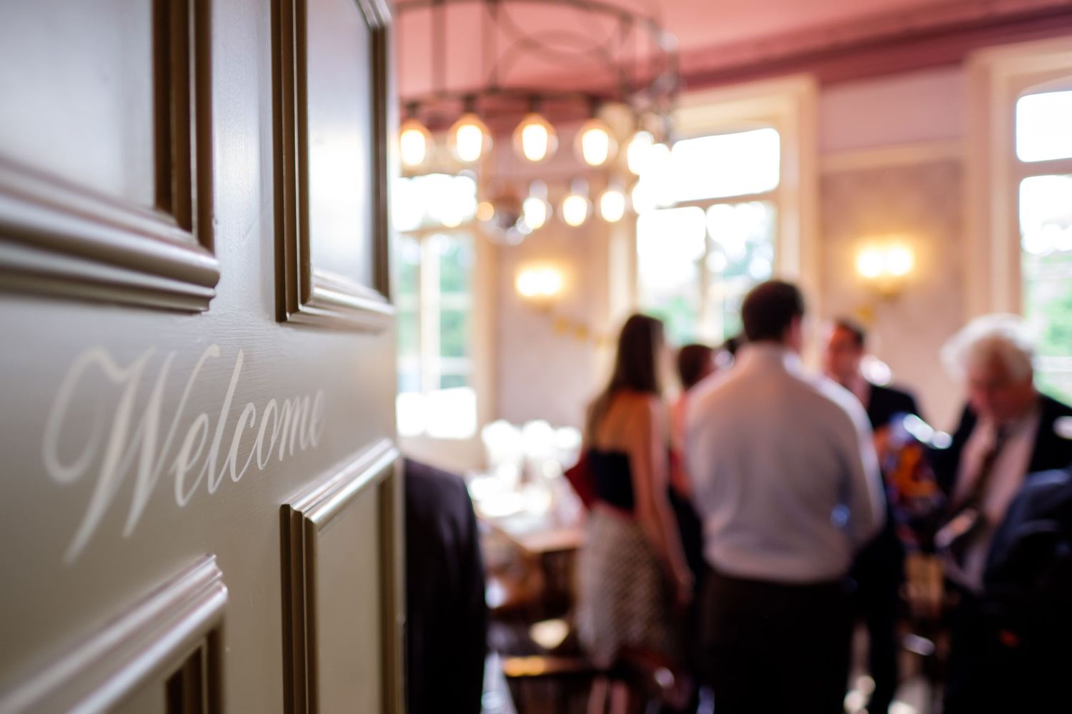 Indoor wedding reception venue with warm lighting and decorative welcome sign.