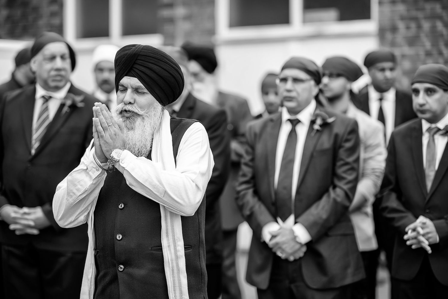A black and white photo of elderly men in traditional Sikh attire at a formal gathering.