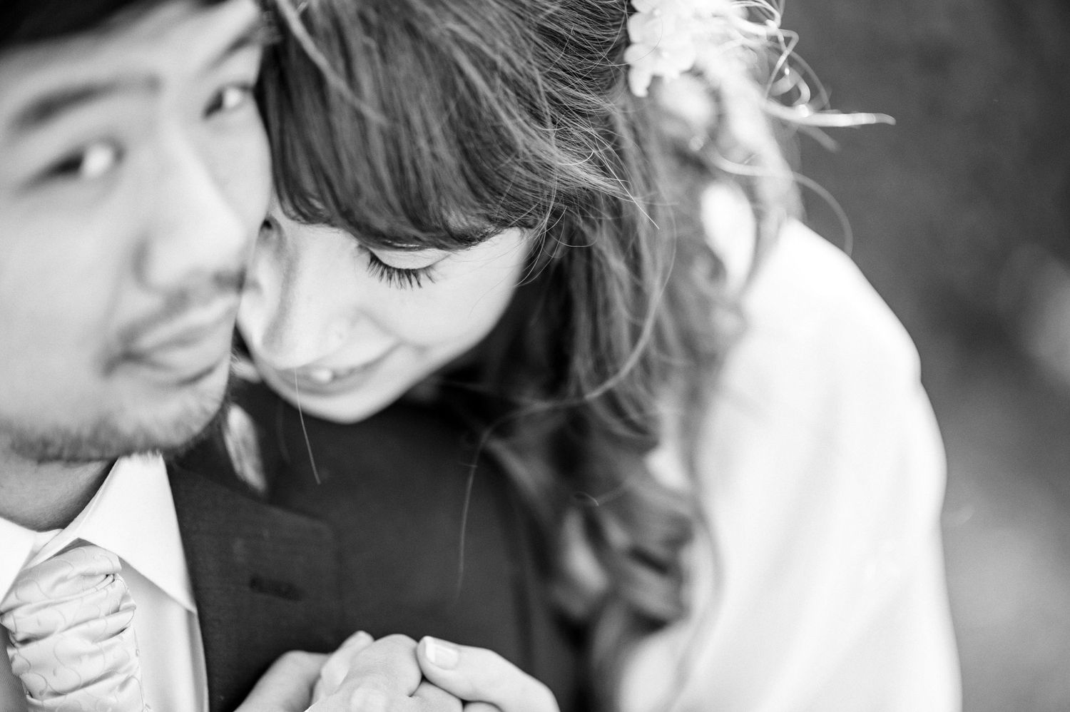 Close-up black and white romantic moment between newlyweds during wedding photoshoot.