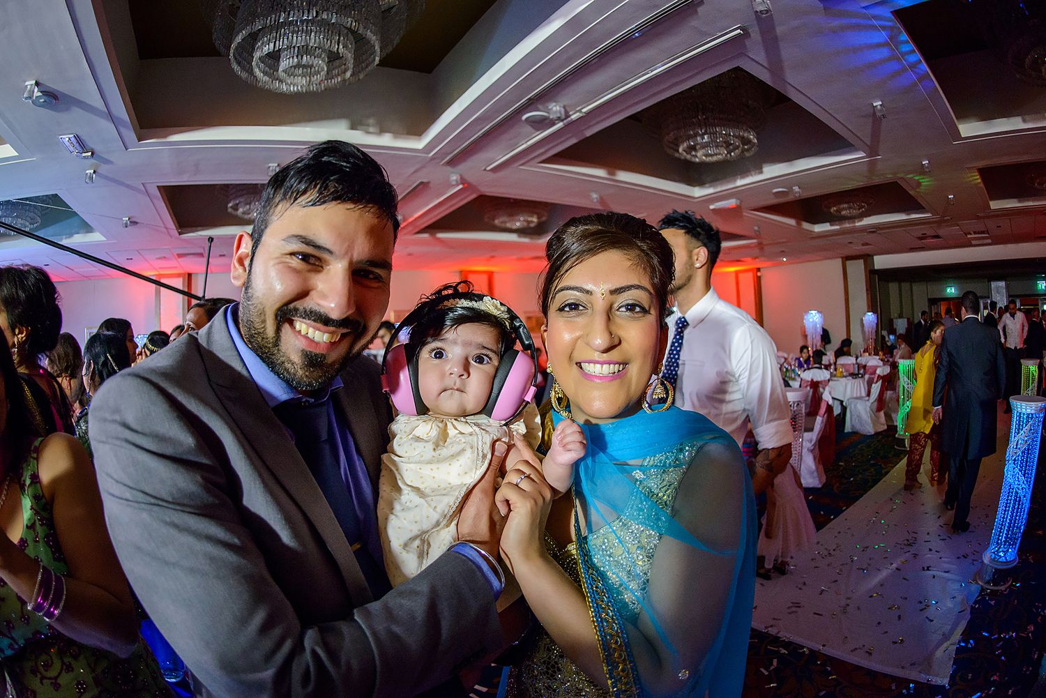 Wedding reception venue with dramatic red and blue lighting creating festive atmosphere.