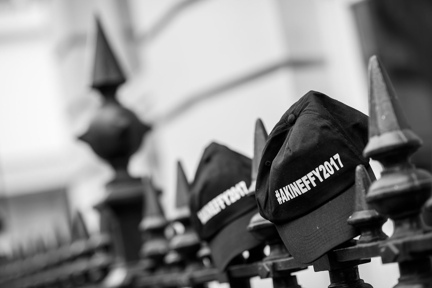 Row of vintage style black hats lined up on display creating dramatic shadows.