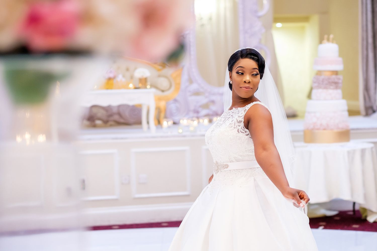 Elegant wedding reception hall decorated with soft lighting and floral arrangements.