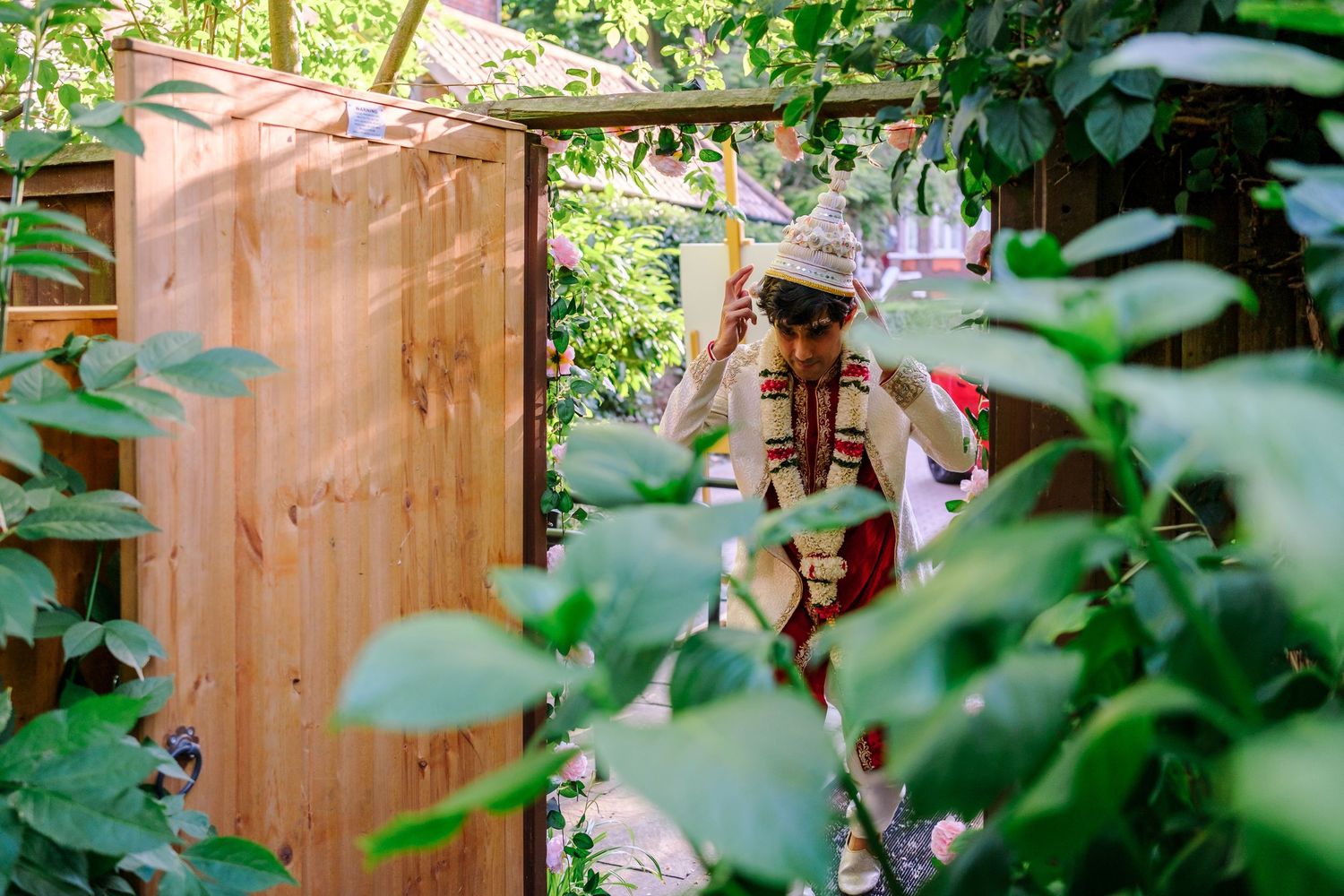 A wooden outhouse structure nestled among lush green foliage in a garden setting.
