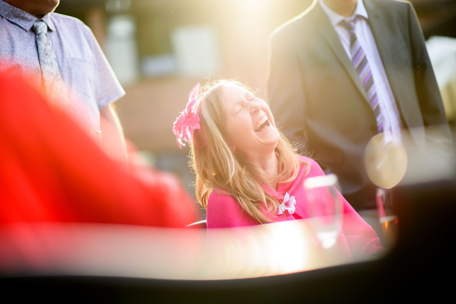 Wedding party members share laughs and smiles during an outdoor celebration.