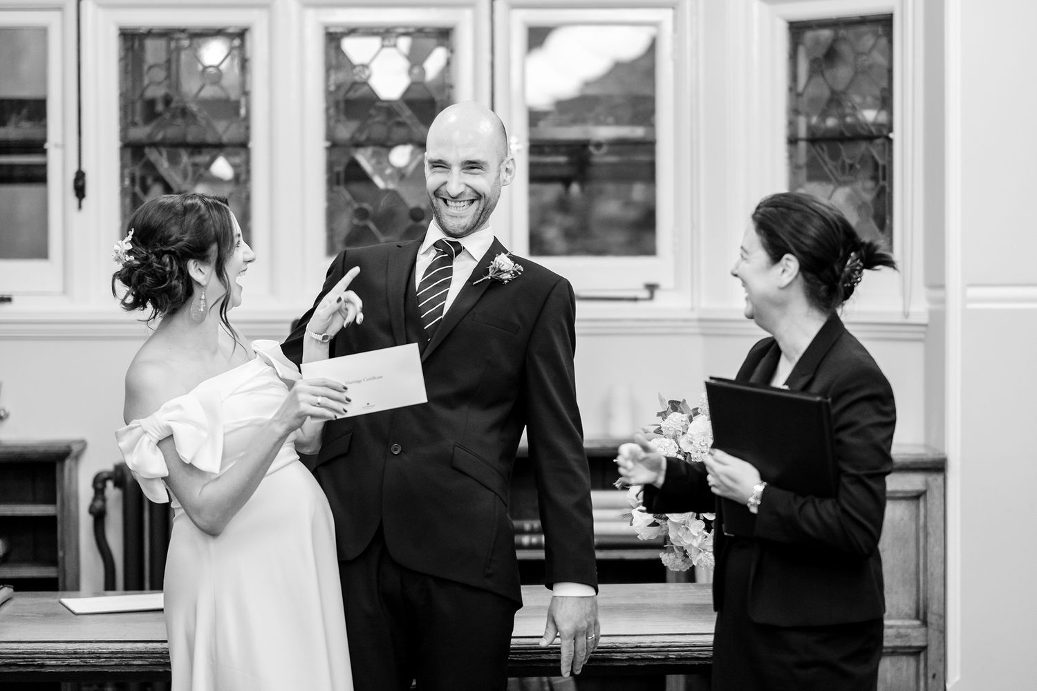 Elegant hallway scene at a wedding venue with formal attire and natural light.
