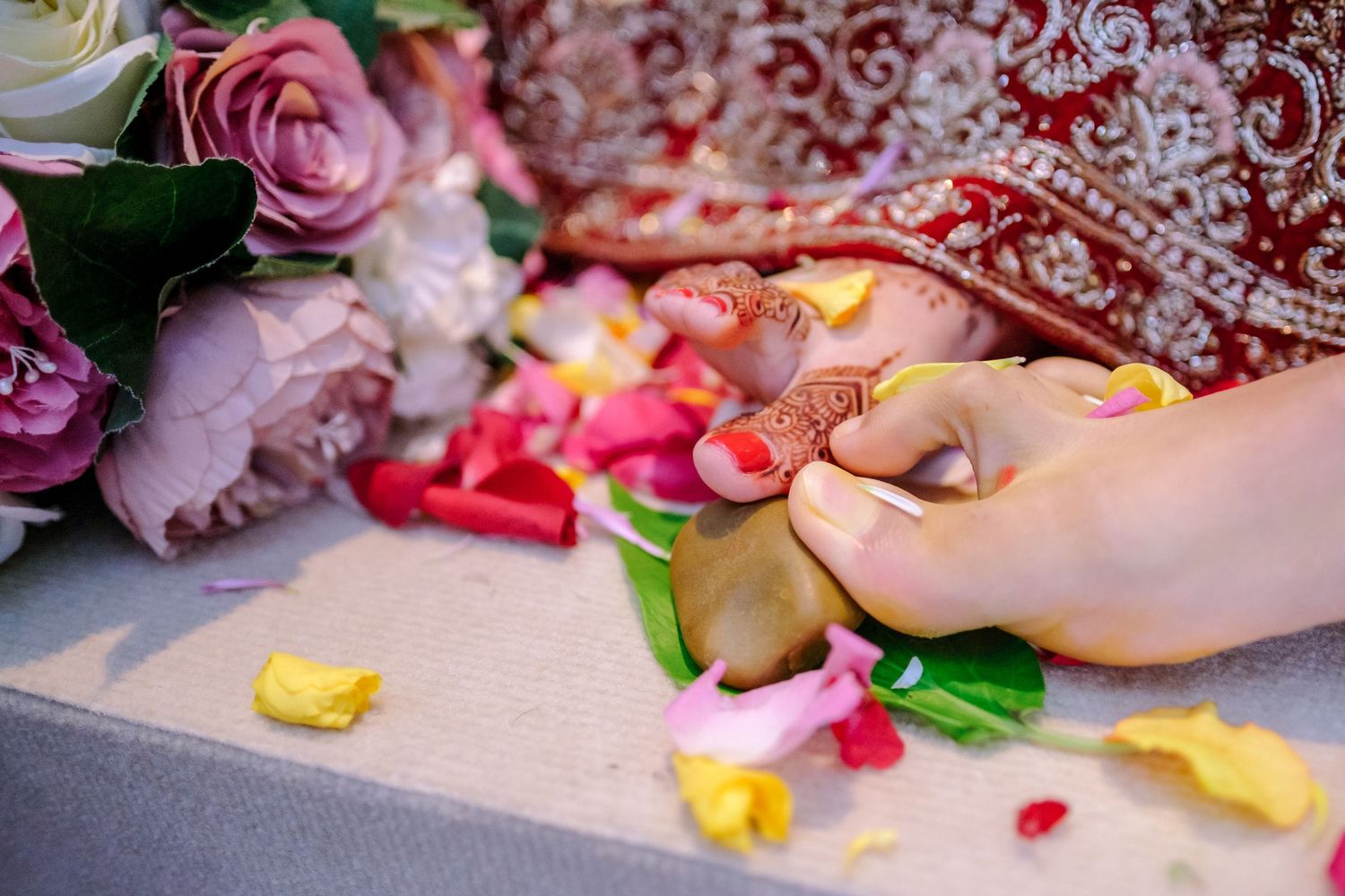 Pink and red rose petals scattered on a light colored surface at a wedding celebration.