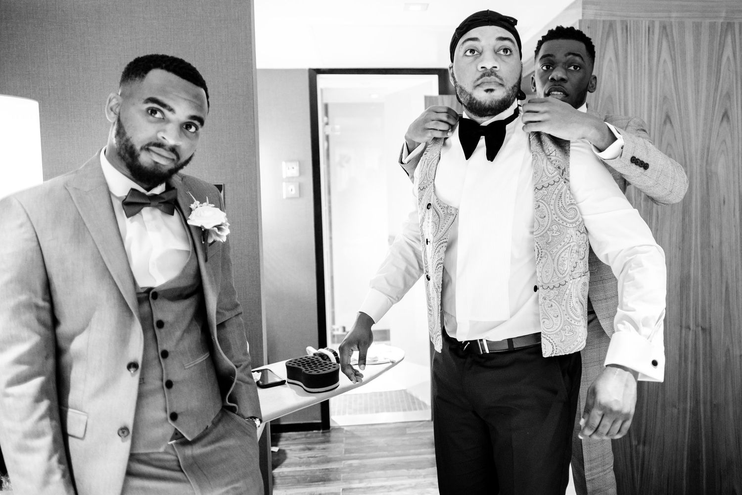 A collection of black and white photos showing groomsmen getting ready for a wedding in formal attire.