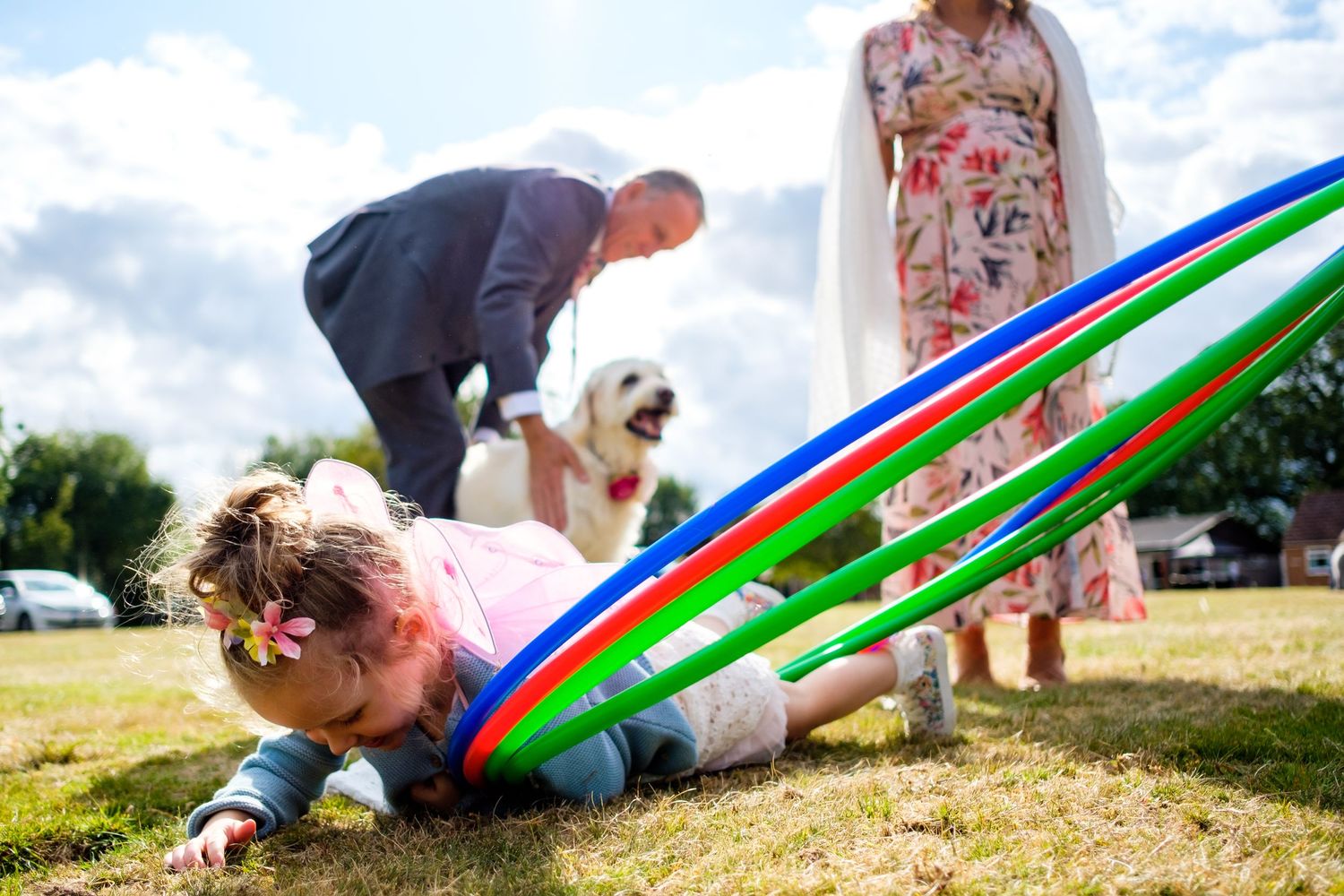 Colorful parachute games being played on a grassy field during wedding festivities.