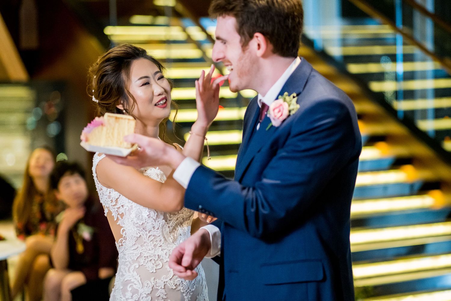 Newlyweds share a romantic dance moment under warm lighting at their wedding reception.
