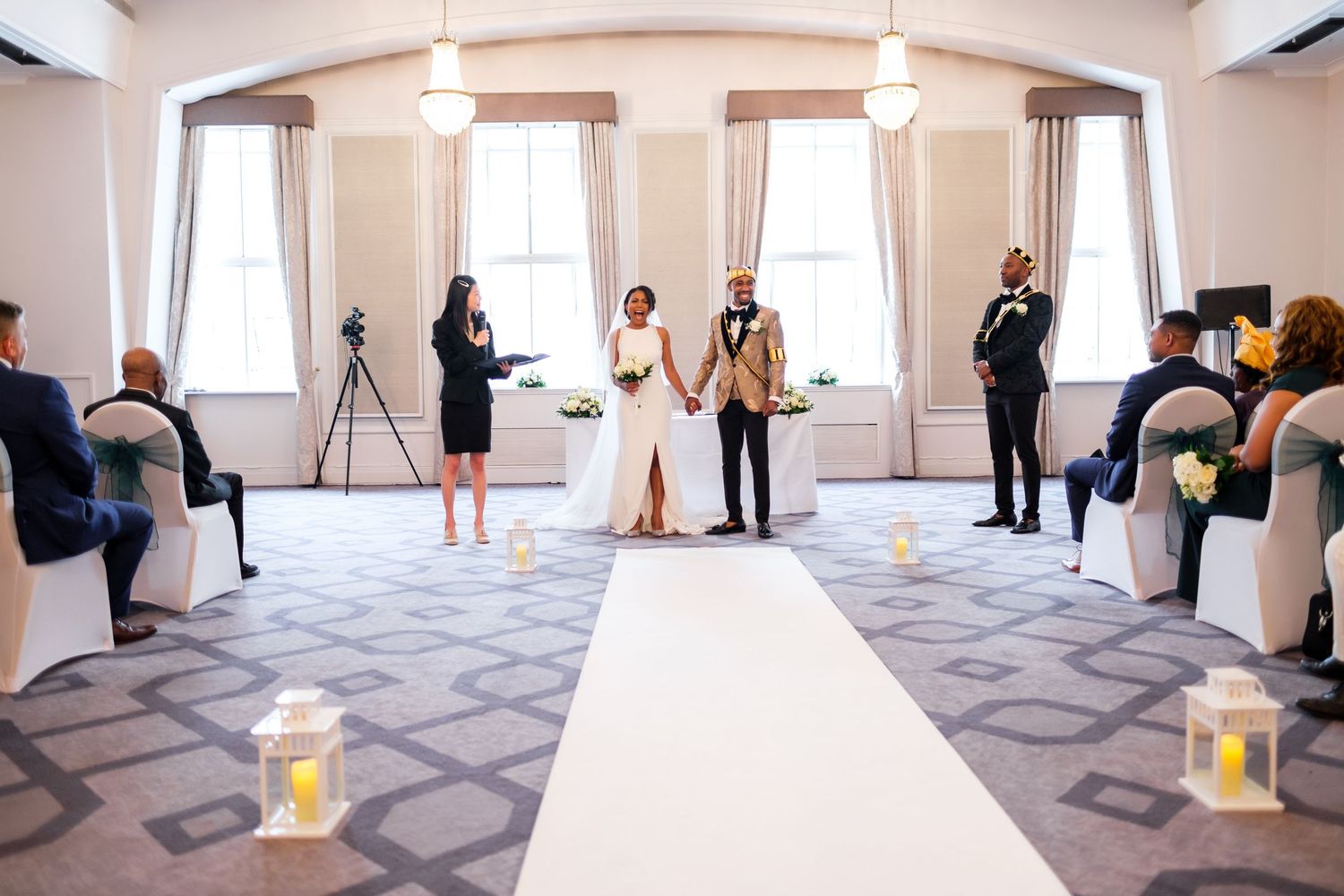 Wide angle view of an elegant white wedding venue with geometric carpet patterns.
