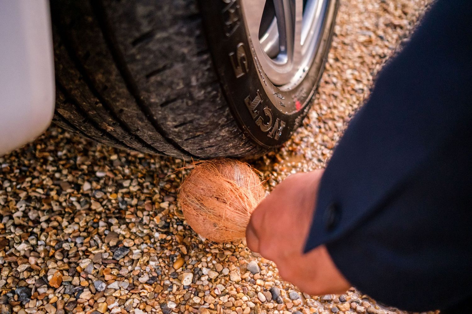 Close-up view of formal shoes walking on gravel path.