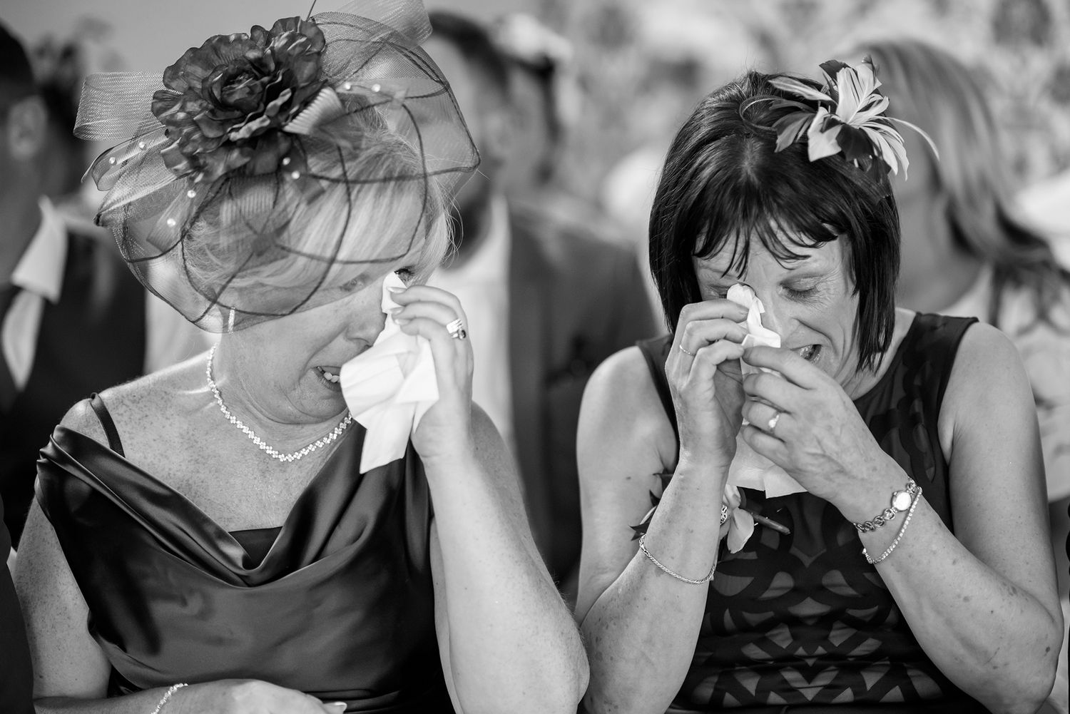 Black and white candid photographs showing emotional reactions and spontaneous moments at a social gathering.