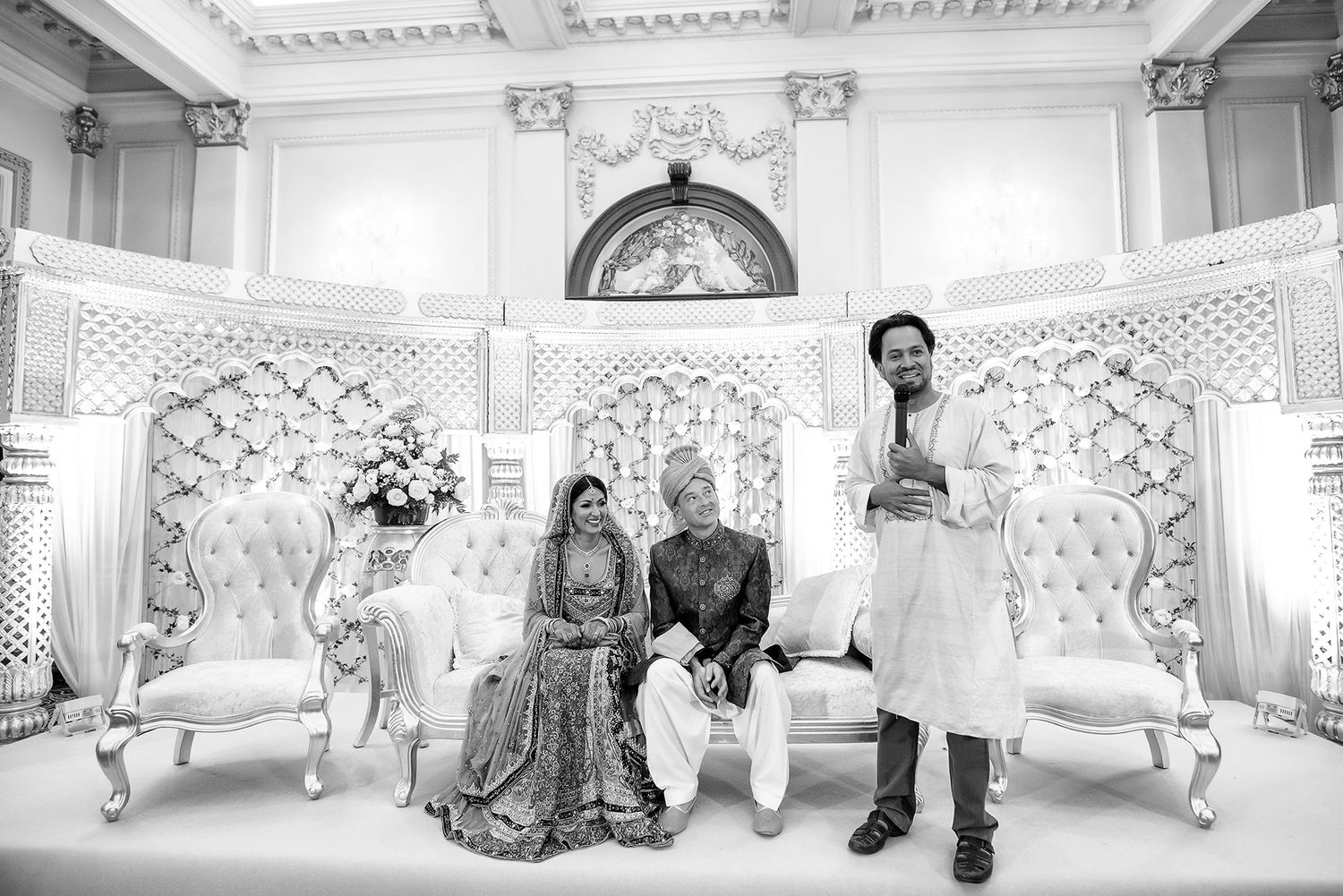 Elegant white and gold wedding reception venue with ornate seating and decorative details.