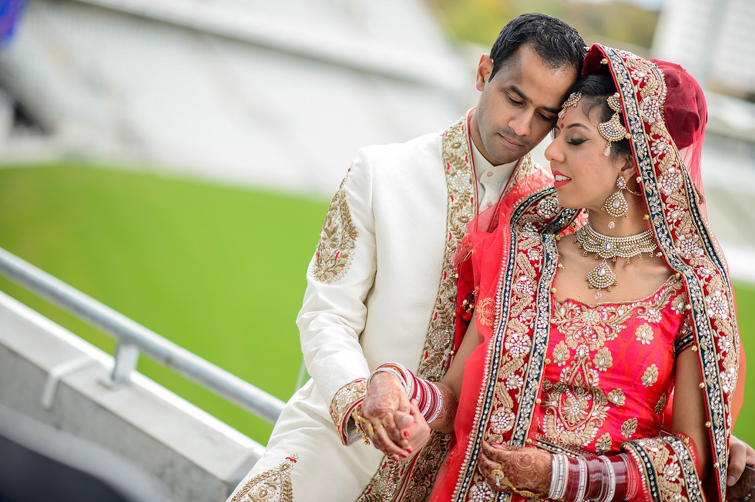 Traditional wedding photography session with couple in red and cream outfits.