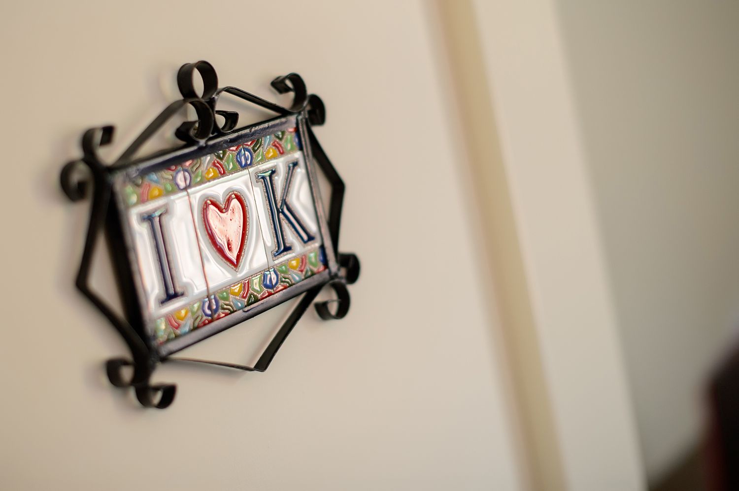 Decorative wall signs with ornate black metal frames in a neutral-toned hallway.