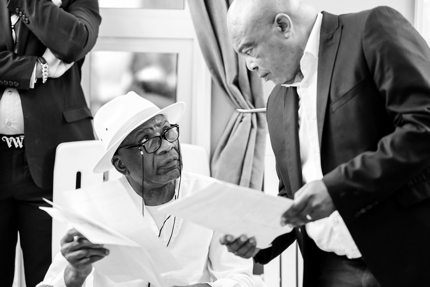 Black and white image of hands holding documents during formal meeting.