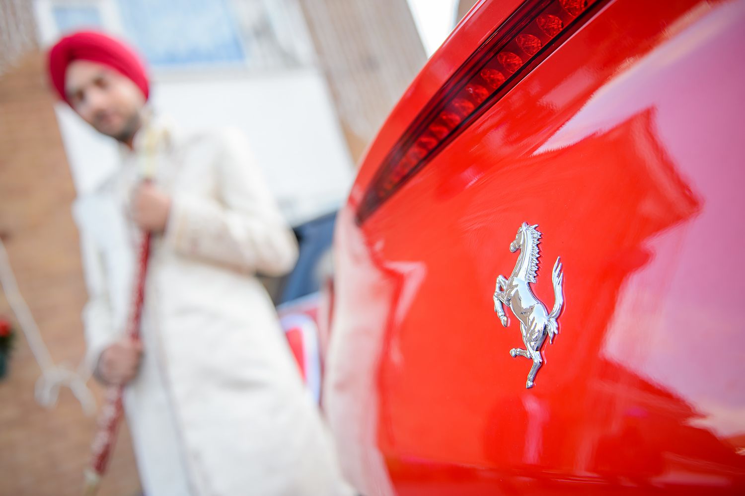 Bright red Ferrari sports car parked at a formal event.