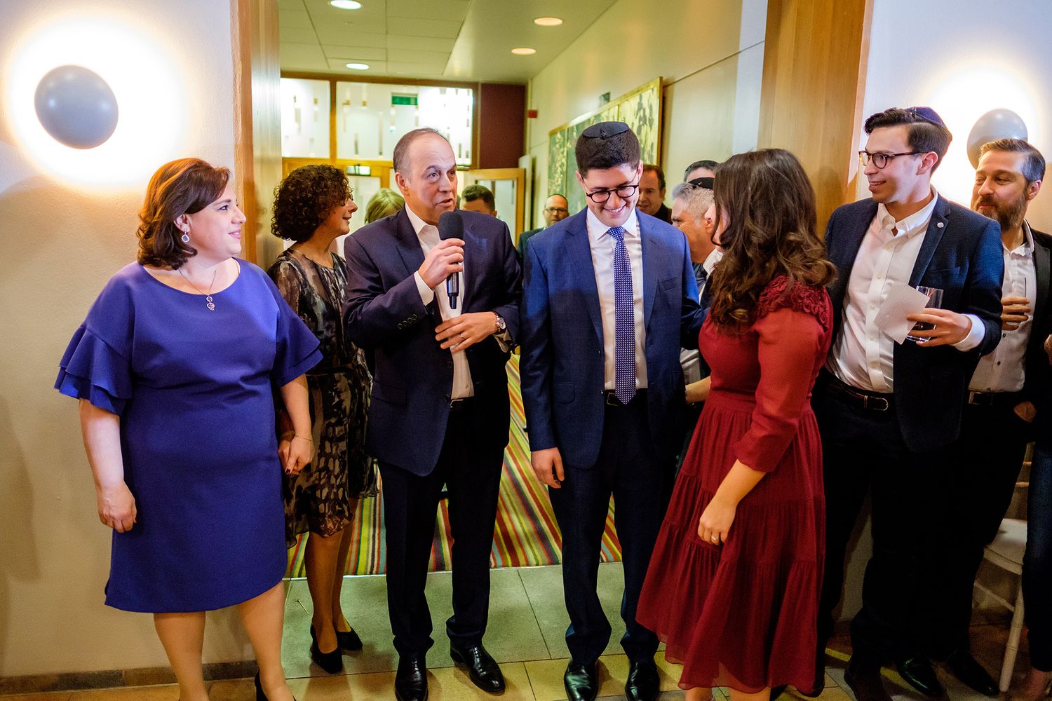 Panoramic view of corporate event space with guests wearing formal business attire.