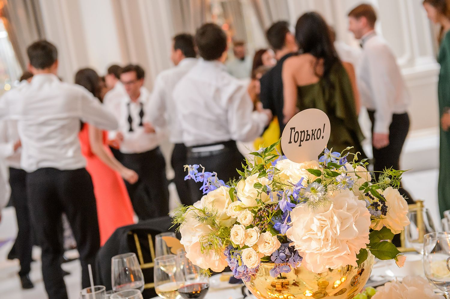 Elegant wedding reception table with floral centerpieces and glowing candles in a luxurious venue.