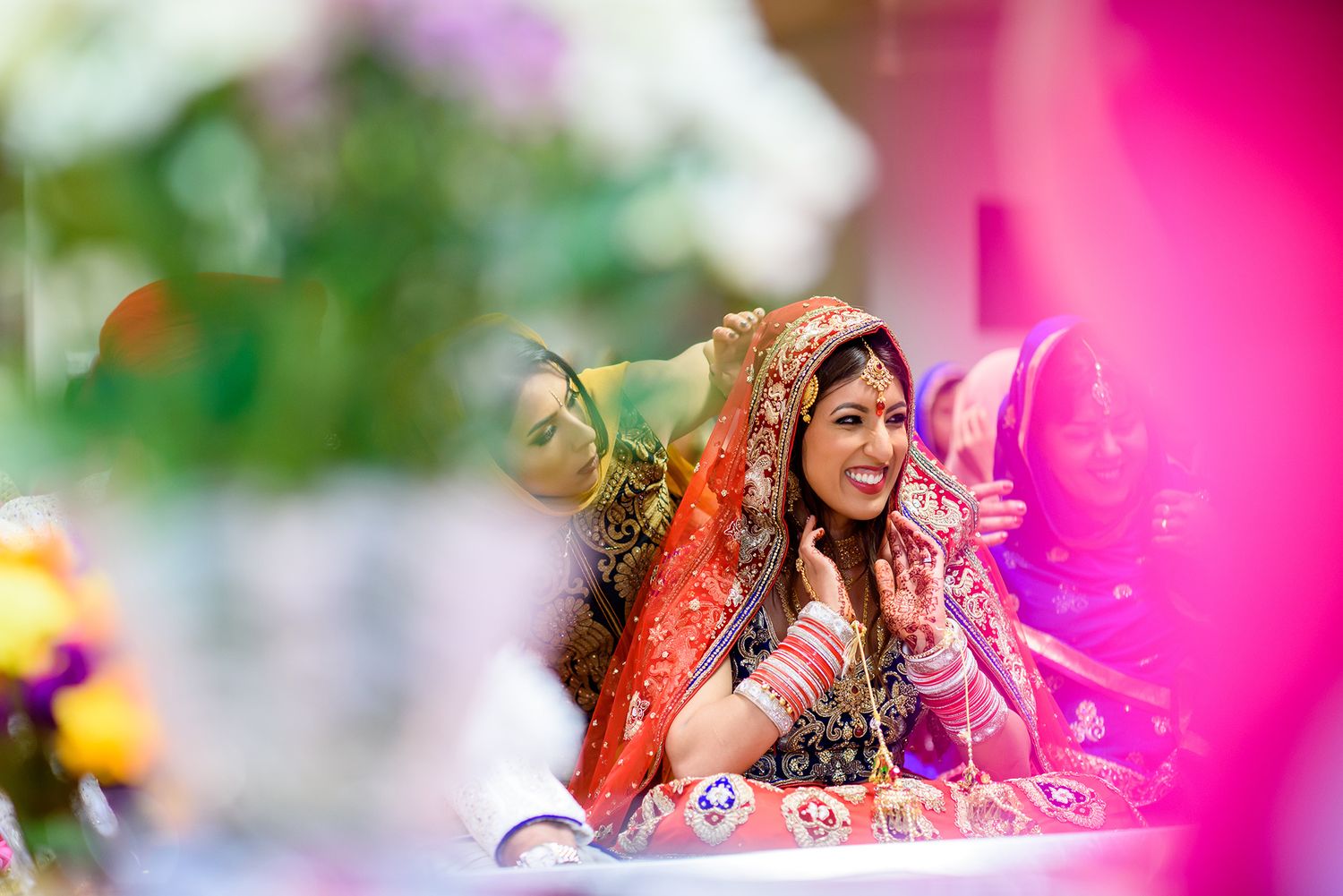 Traditional Sikh wedding ceremony with vibrant pink decorations and floral arrangements.