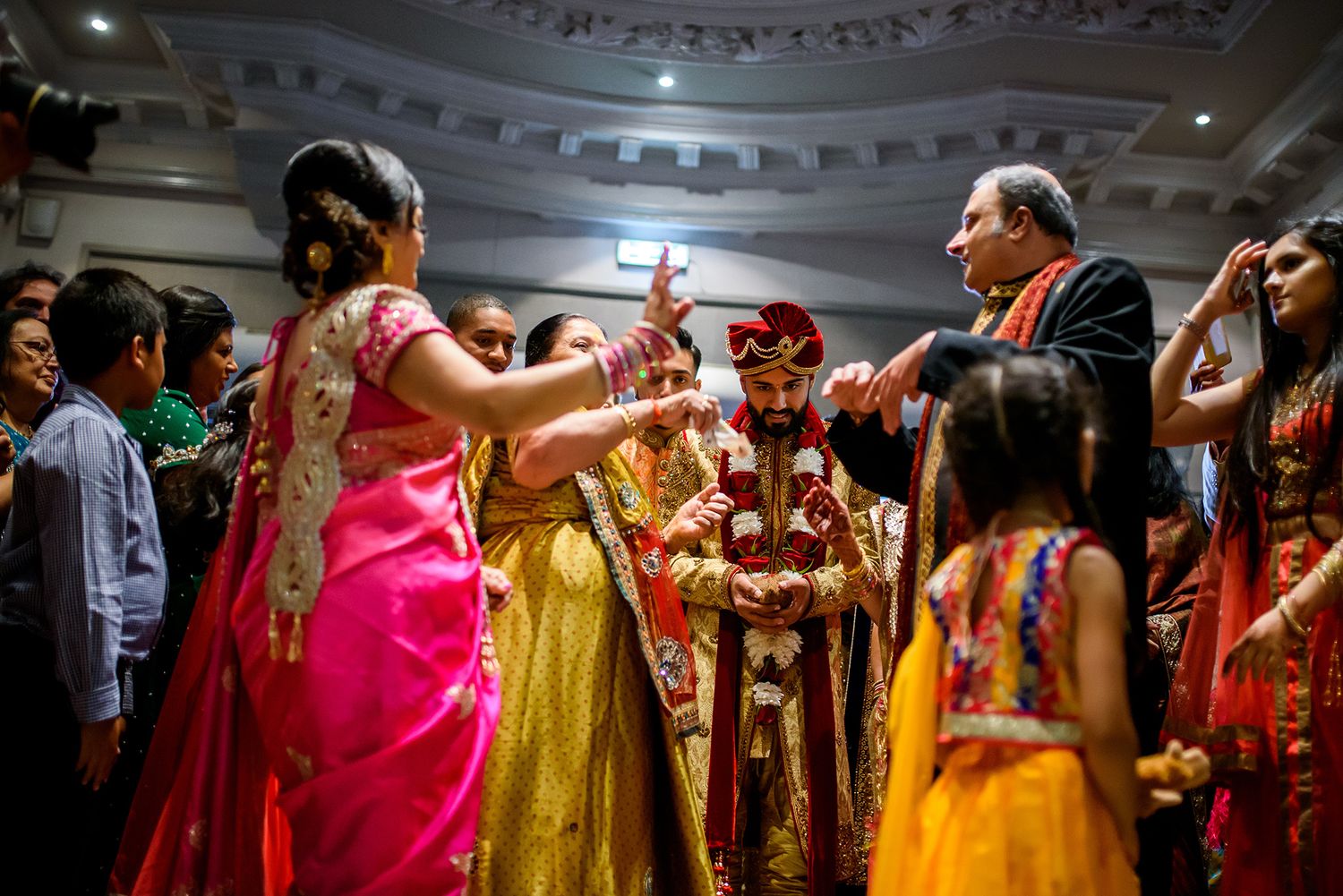 Panoramic view of guests in colorful traditional Indian attire at a wedding reception.