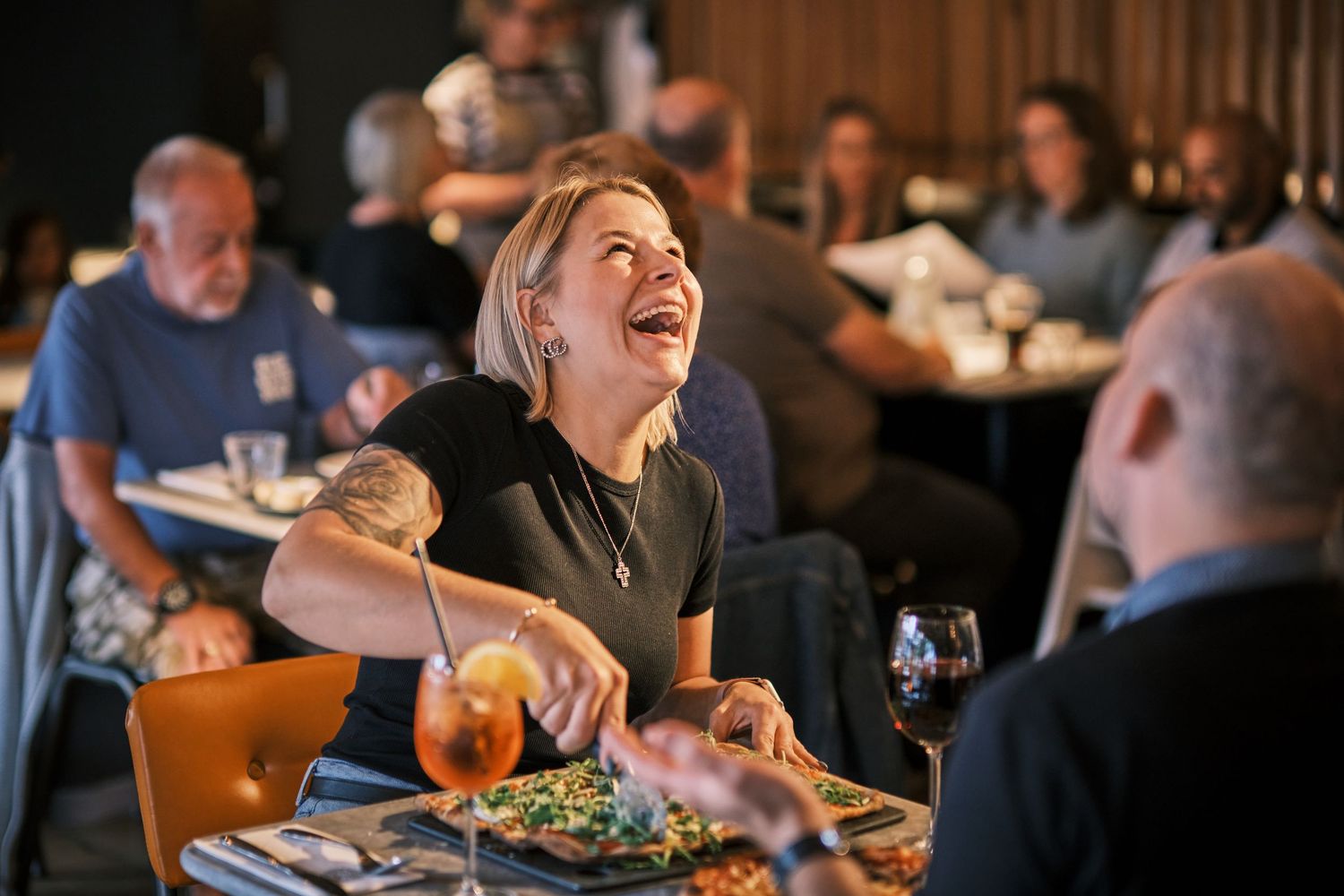 Diners enjoying a lively meal and conversation in a bustling restaurant setting.