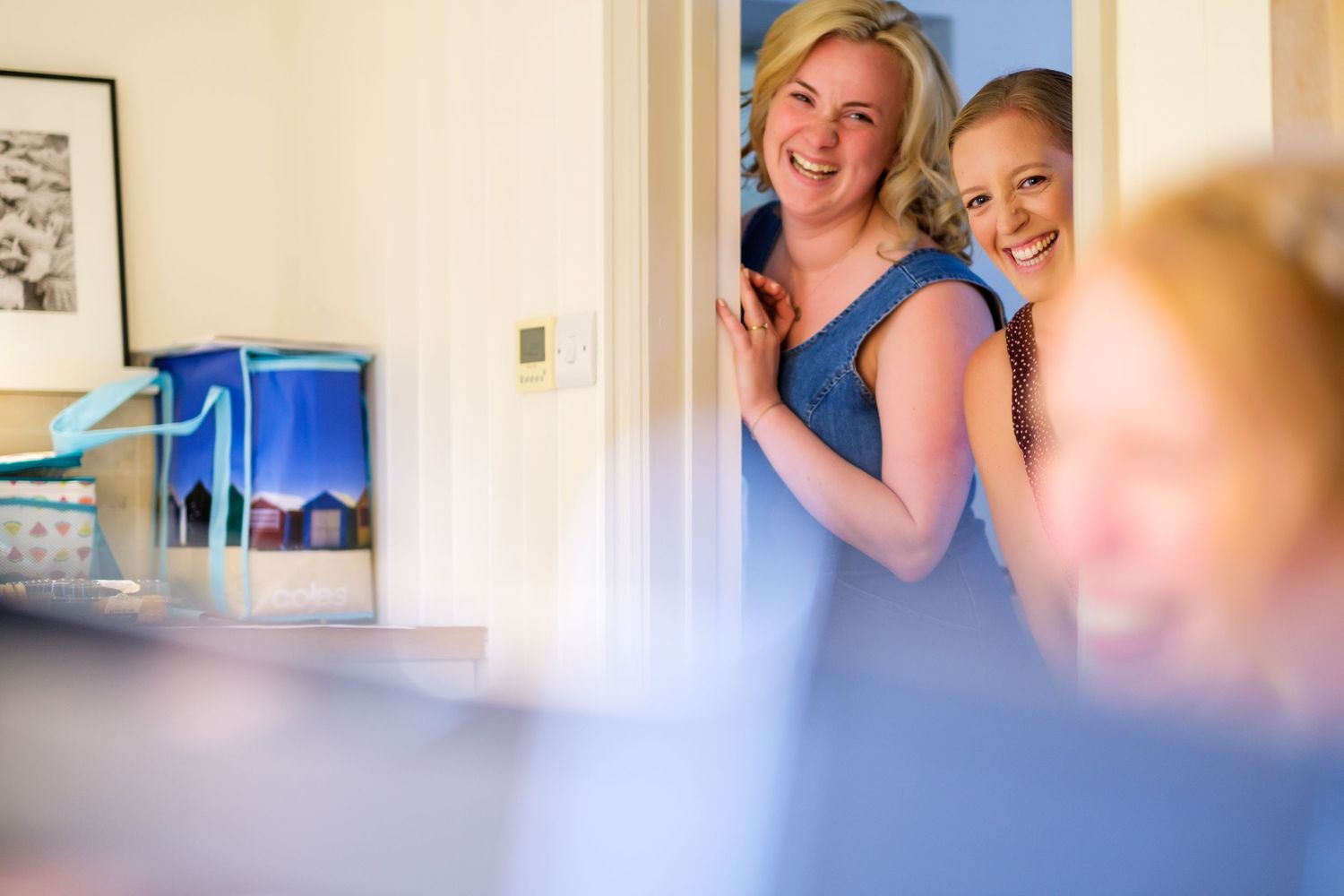 Smiling people in a bright, modern home setting with natural lighting streaming through windows.