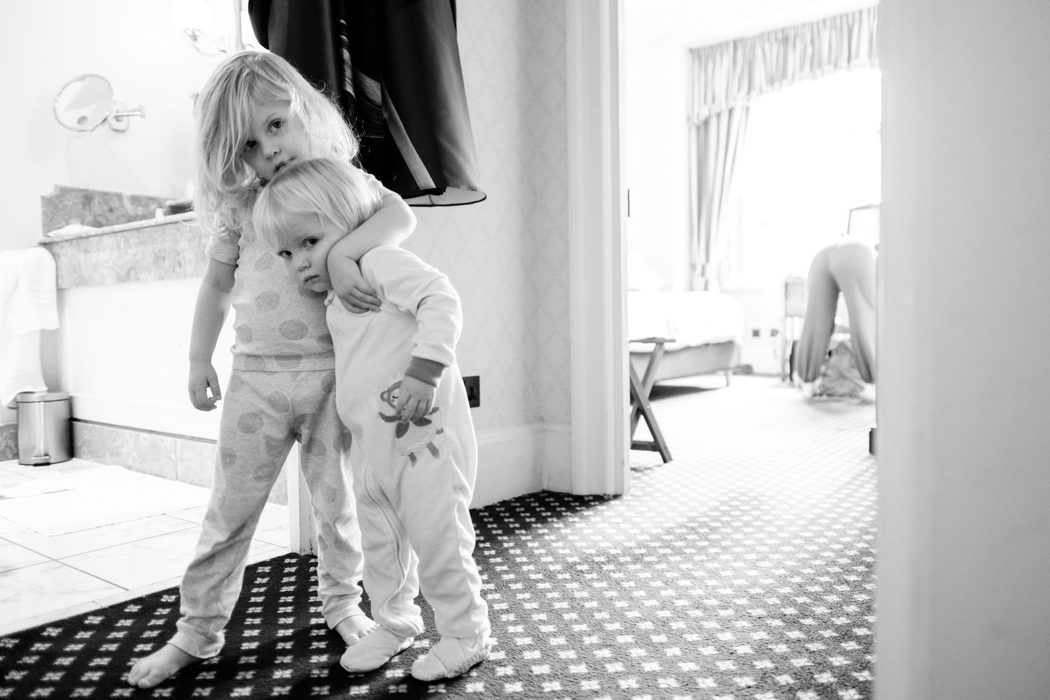 A series of black and white photos showing a couple in wedding attire dancing and embracing in a checkered floor room.