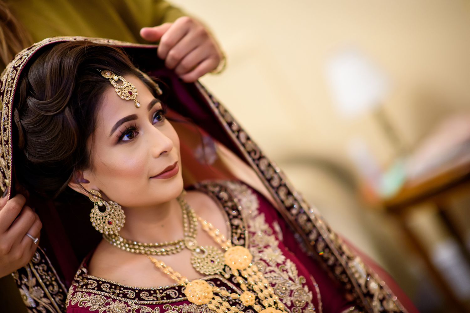 Traditional South Asian bridal attire featuring ornate jewelry and detailed embroidery.
