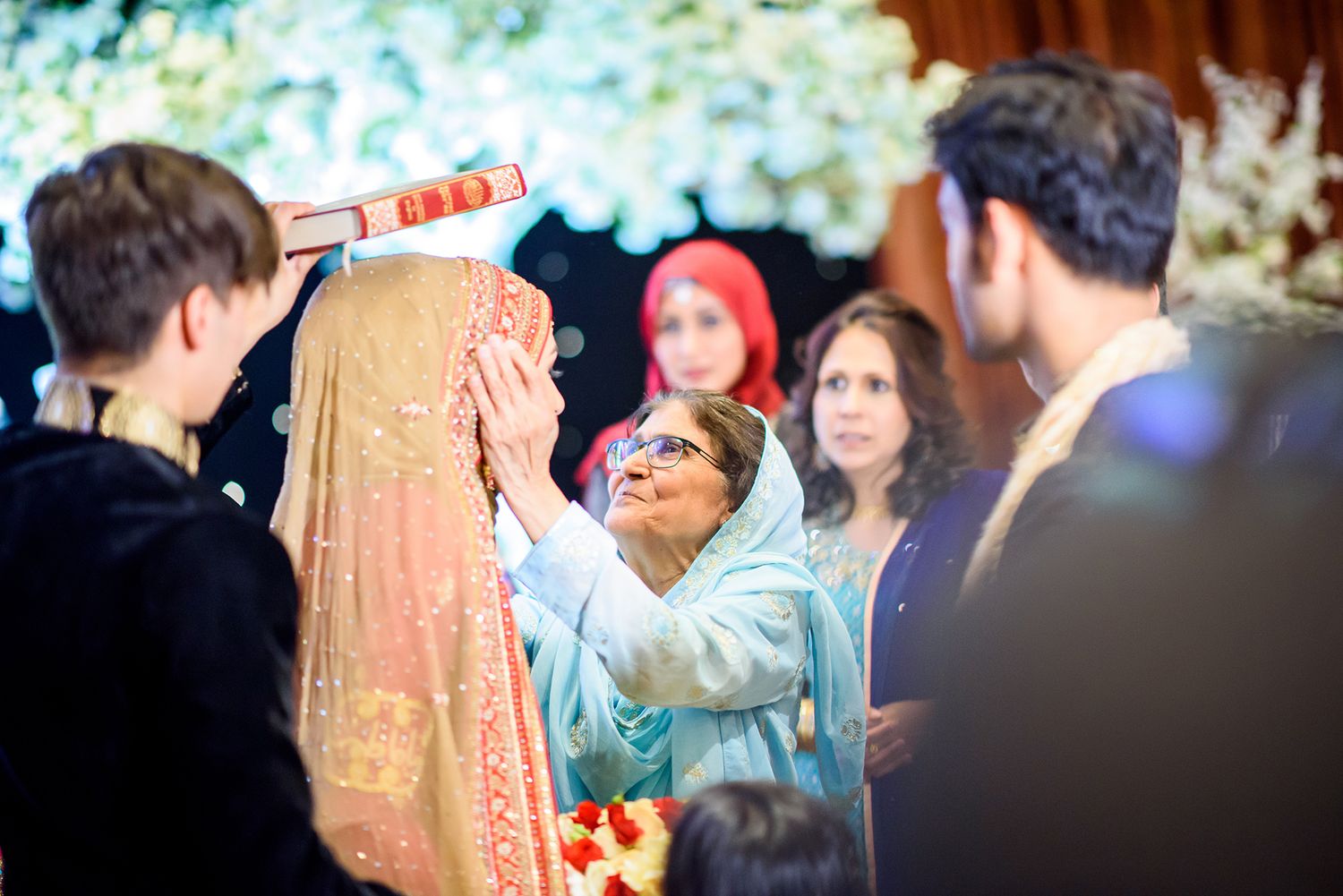 Festive wedding celebration with guests in traditional attire under elegant decorations.
