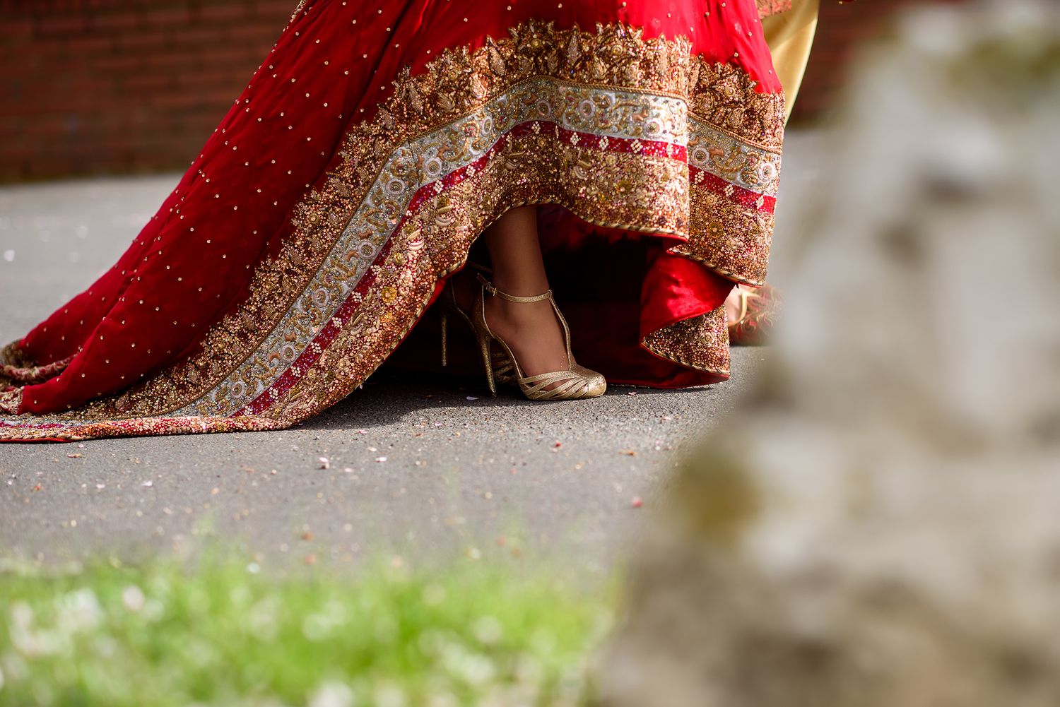 Close-up detail of a red and gold embroidered South Asian wedding dress.