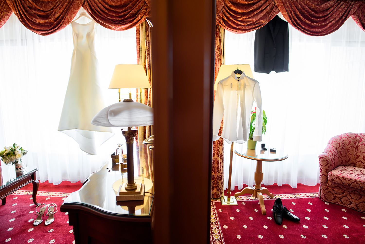 Luxurious room interior with red velvet curtains and natural window light.