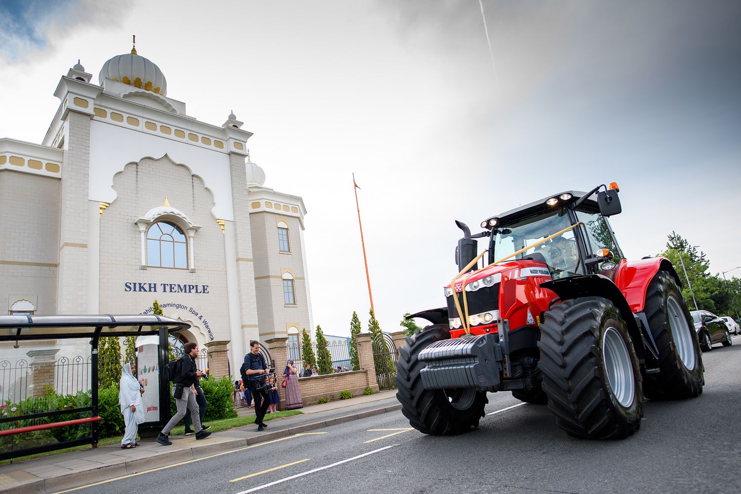 Luxury red tractors parked in front of a white temple building.