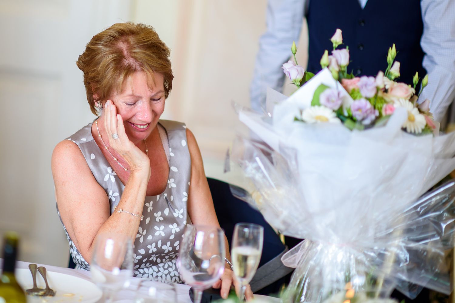Wedding reception guests sharing emotional moments and laughter at elegantly decorated tables.