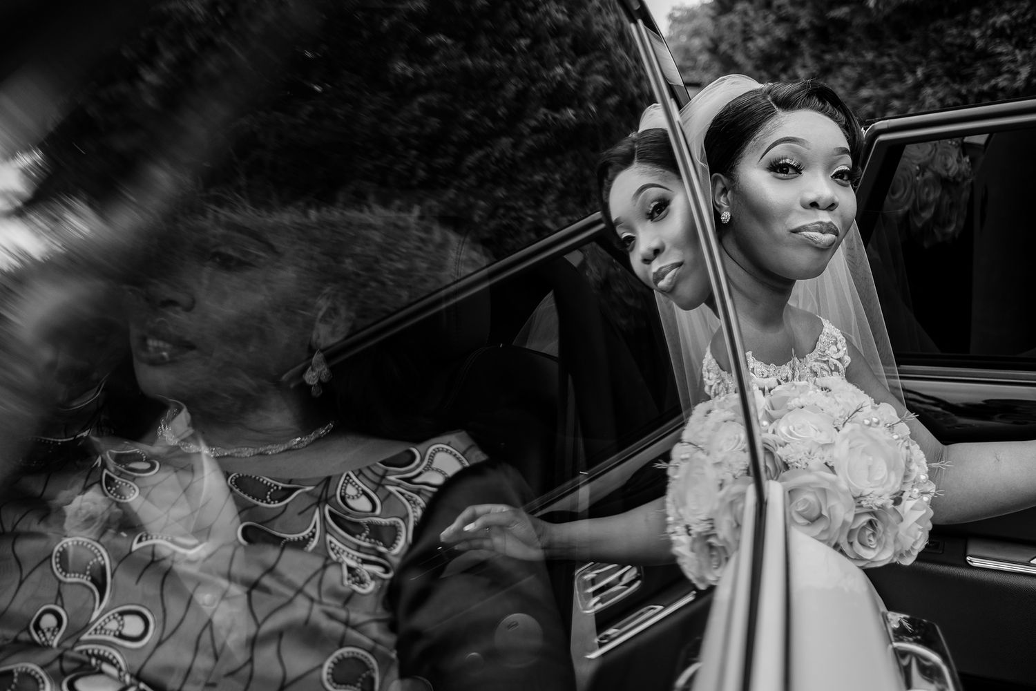 Wedding scene captured through multiple car window frames.