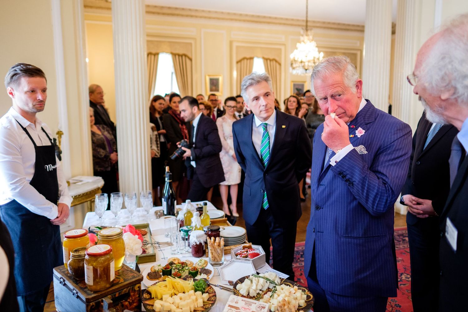 Royal dining event with guests viewing gourmet food display.